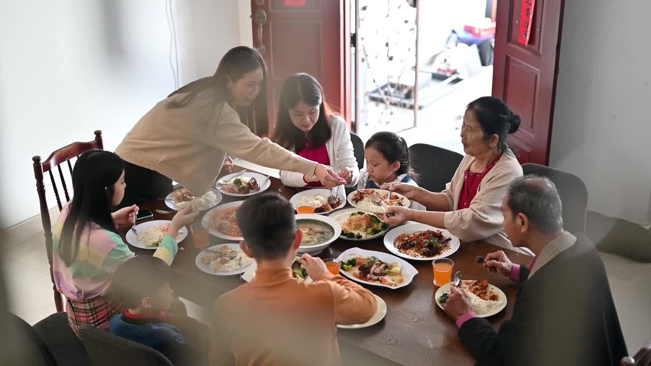 欢乐的亚洲三代家庭在春节期间在家里庆祝和享受团圆饭