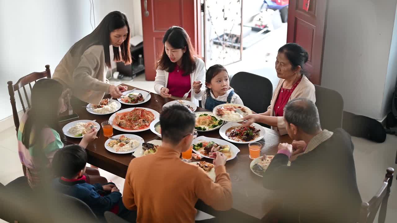 中国农历新年，欢乐的亚洲一家三口欢聚一堂，共进年夜饭
