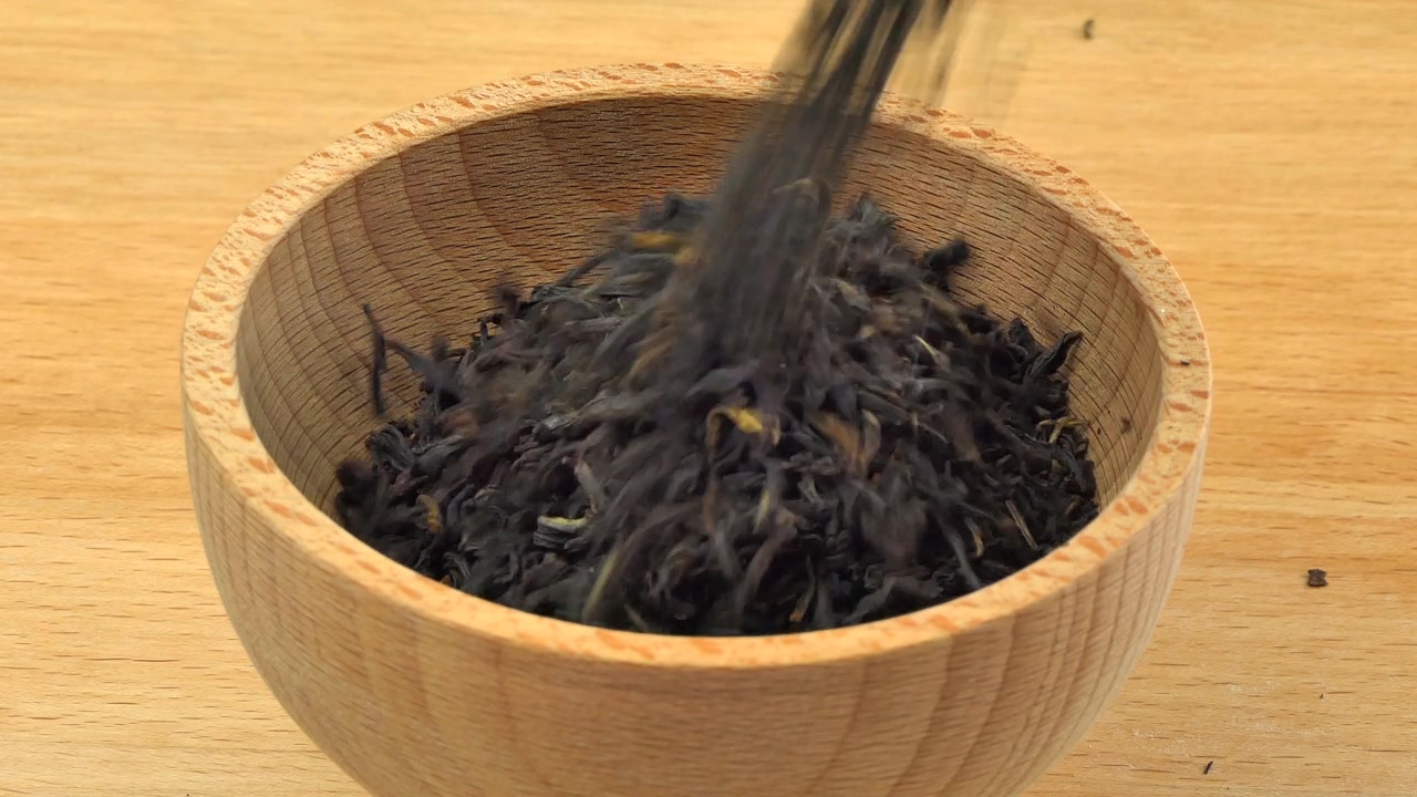 詳情圖-云南紅茶倒入木質(zhì)背景上的木碗中。