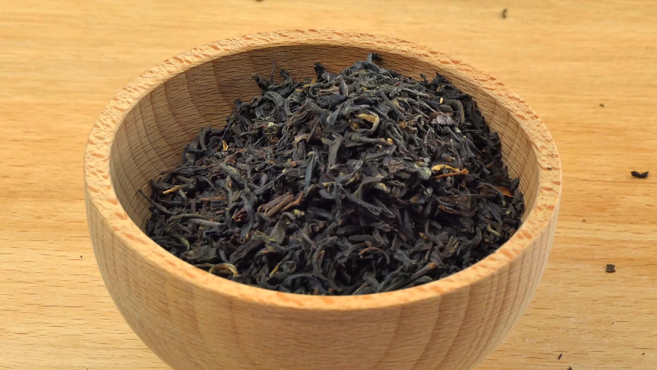 詳情圖-云南紅茶倒入木質(zhì)背景上的木碗中。