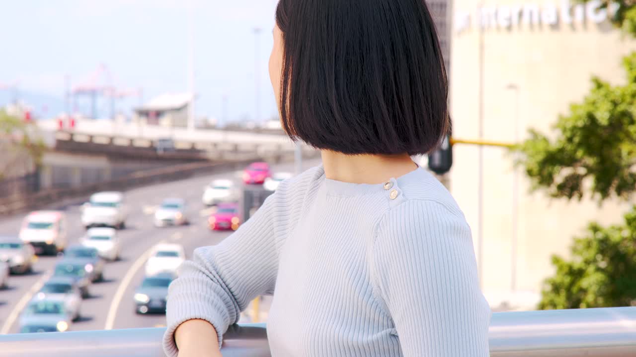 一个美丽的年轻女子看着城市外面繁忙的交通看起来很焦虑的4k视频片段