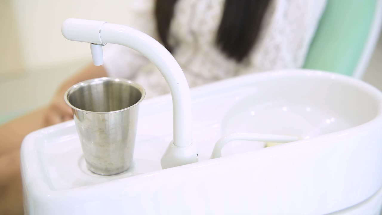 亚洲年轻女子漱口水在牙科诊所完成牙科保健