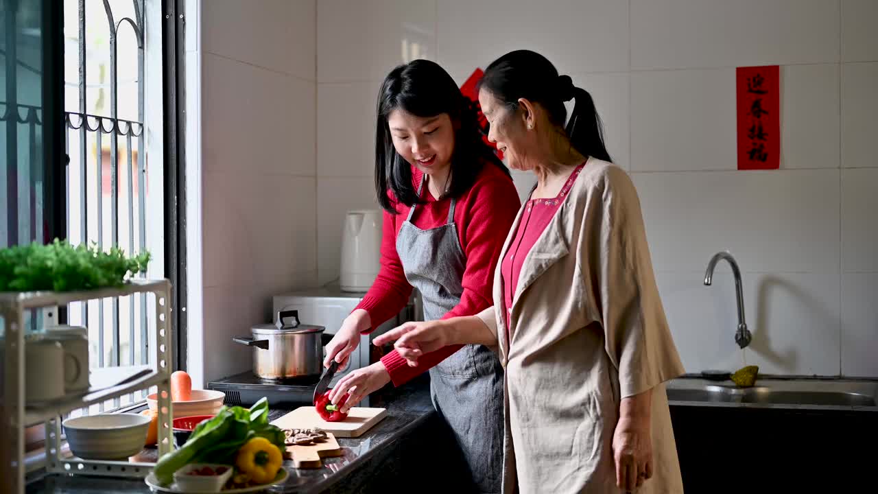 一位亚洲奶奶和她的孙女在为他们的年夜饭准备食物