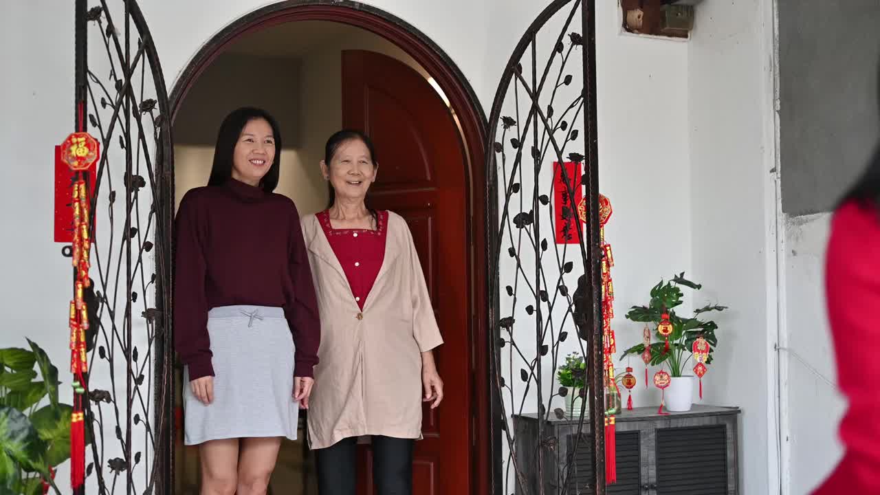 美丽的年轻亚洲妇女访问她的祖父母家给父母的礼物和食物在中国新年