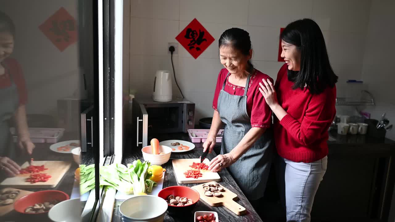 一位亚洲奶奶和她的孙女在为他们的年夜饭准备食物