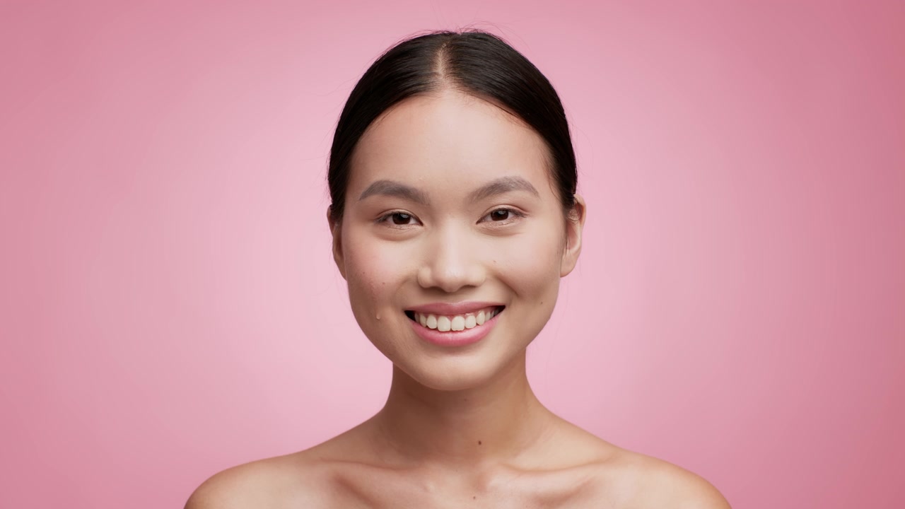 詳情圖-亞洲女性使用滴管在粉紅色背景上使用面部精華液