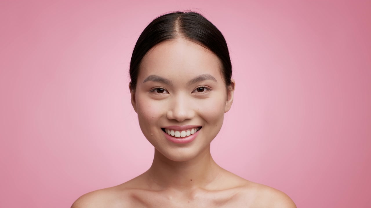 詳情圖-亞洲女性使用滴管在粉紅色背景上使用面部精華液