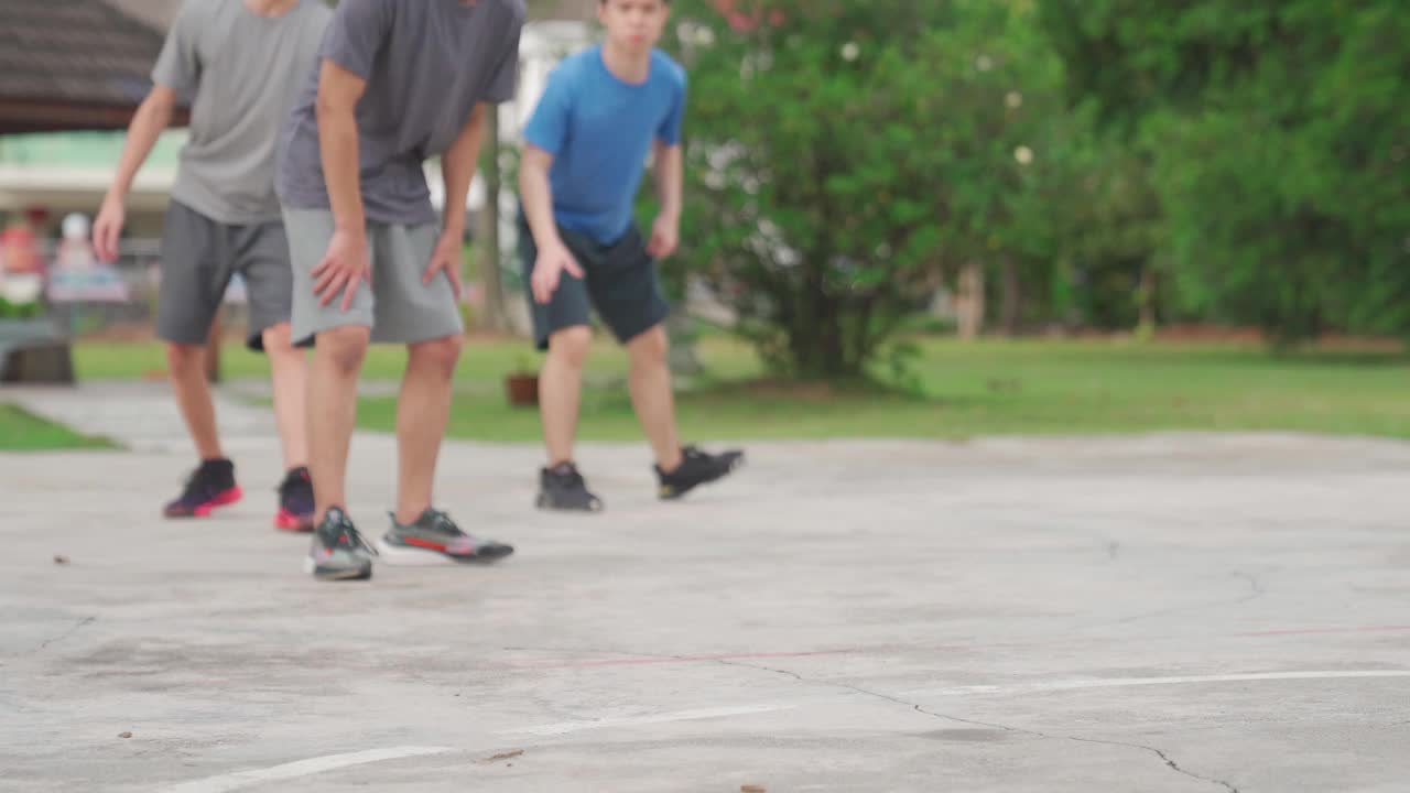 Z一代亚洲中国少年男孩挑战球员，并在周末早上和朋友们一起练习篮球