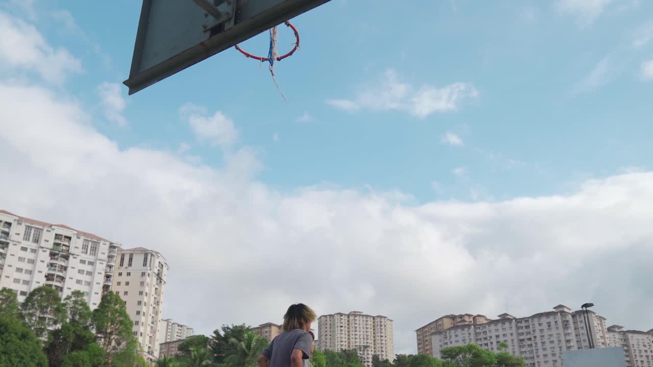 Z一代亚洲中国少年男孩挑战球员，并在周末早上和朋友们一起练习篮球