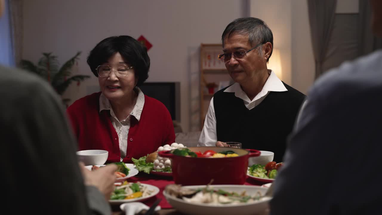 年夜饭的时候，老夫妇的爷爷和奶奶在给家人敬酒，庆祝春节
