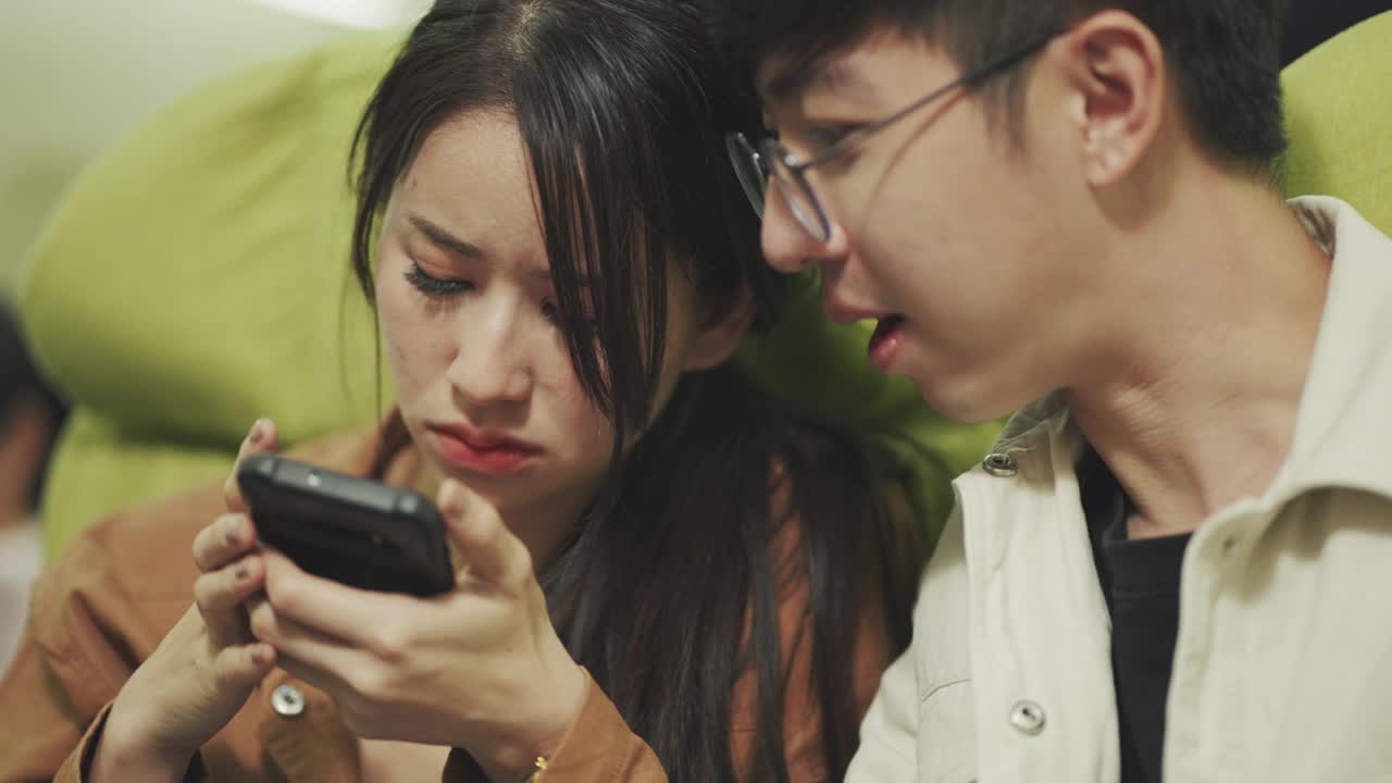 夫妇在飞机等候时玩智能手机。
