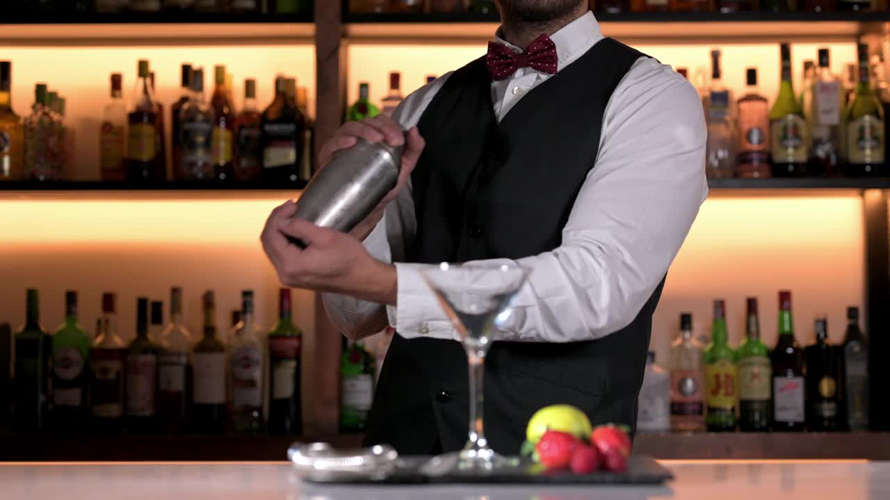 很酷的专业调酒师调制鸡尾酒，摇调酒器。现代酒吧里正宗的调酒师。高质量4k镜头