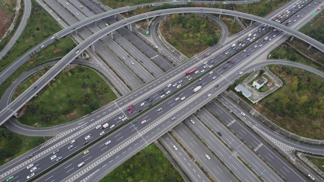 从无人机上俯视大城市多车道高速公路现代交通枢纽。高速公路上交通拥挤。高架弯道，三叶草桥，无车速限制。