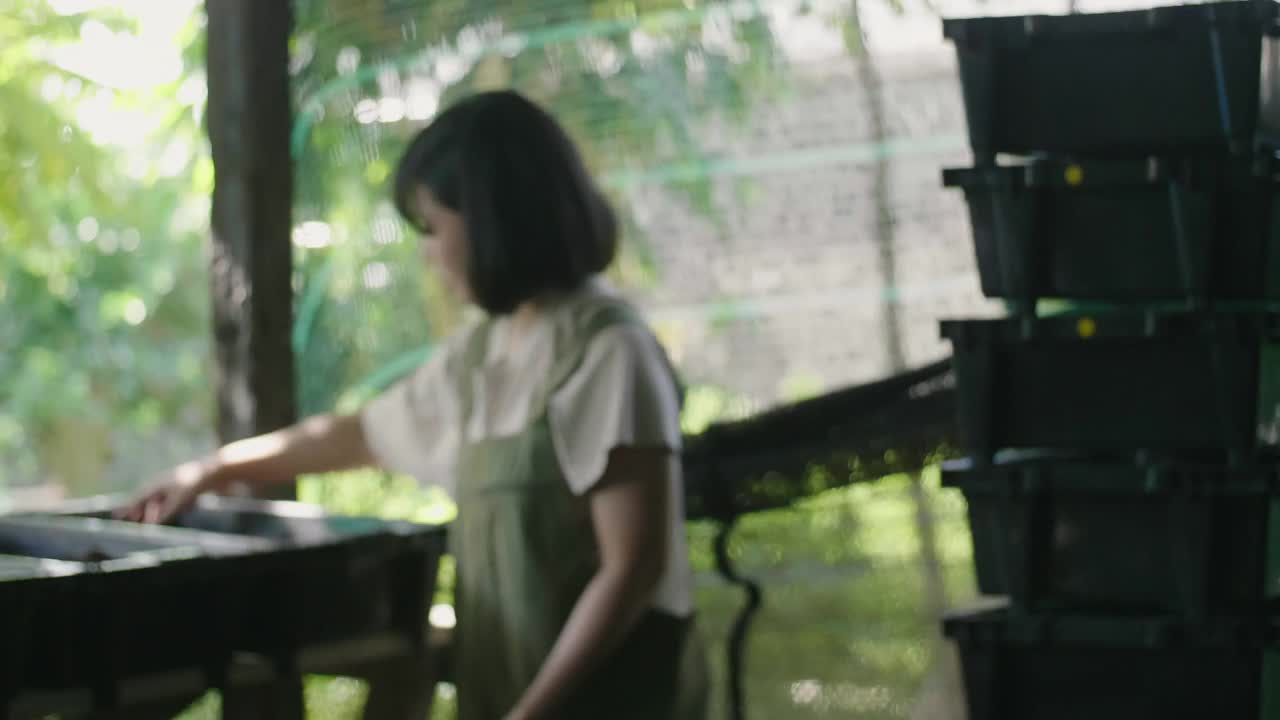 一个女人在户外，手里拿着蚯蚓。