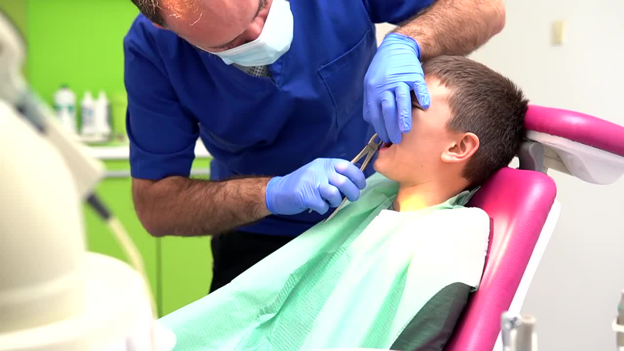 牙医用特制的钳子给男孩拔牙