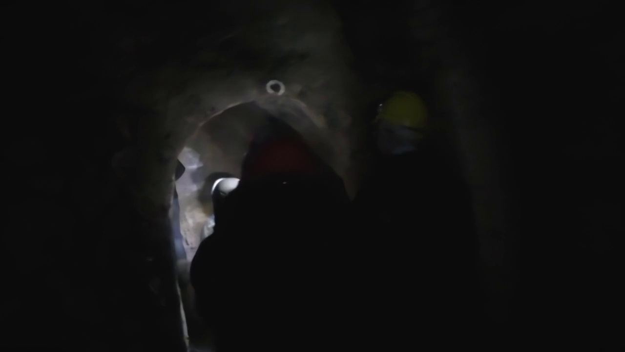 一群游客正在探索黑暗的矿井隧道
