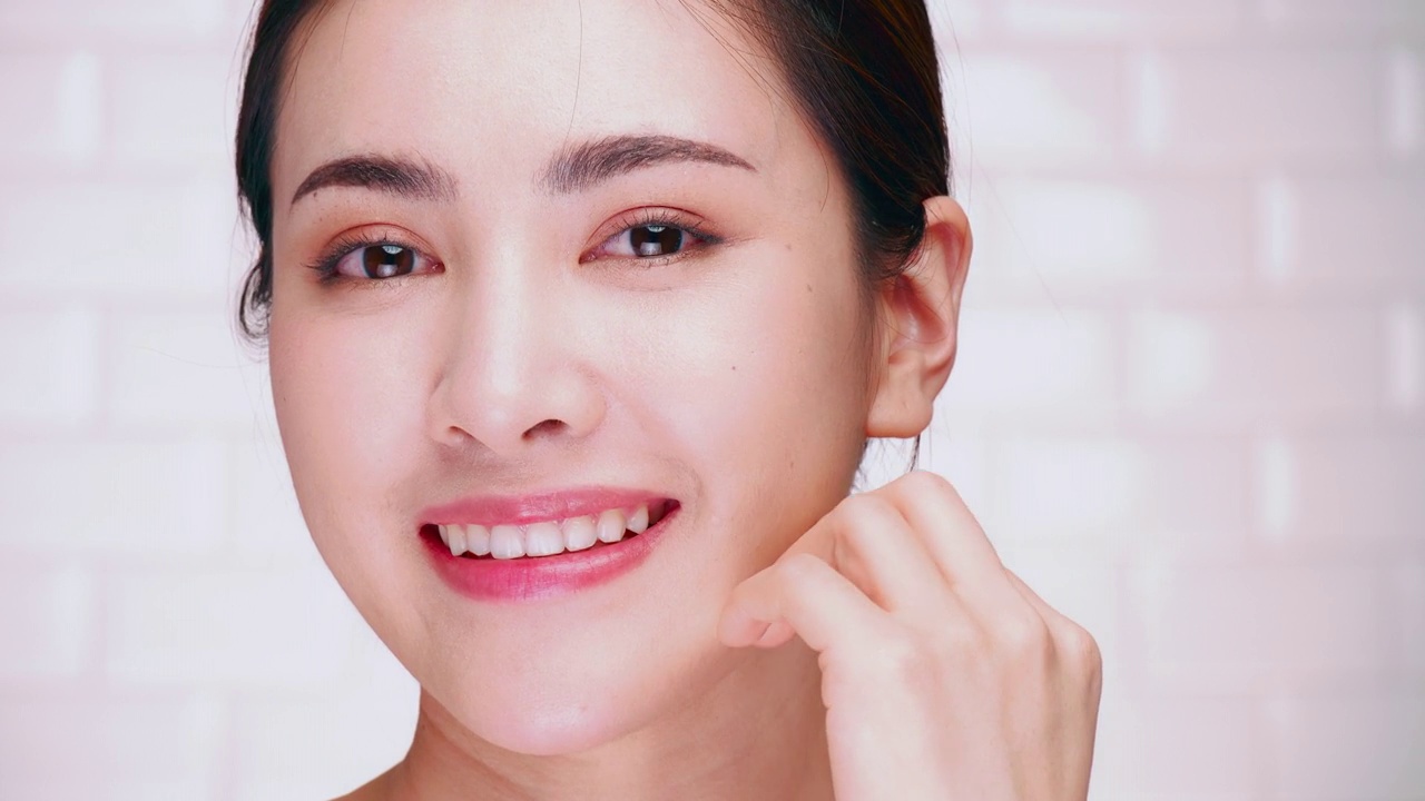 一个微笑着涂面霜的女人的肖像。