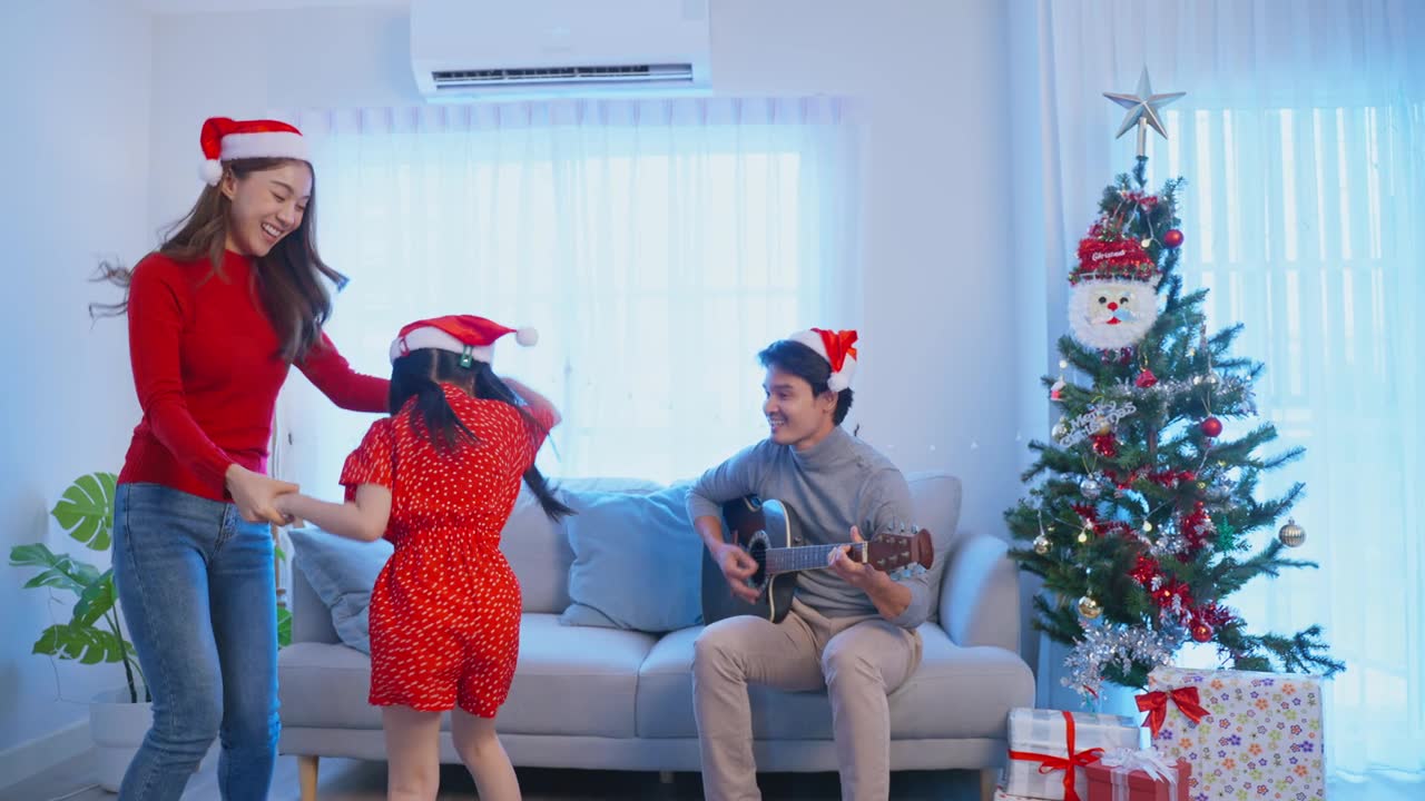 詳情圖-亞洲可愛的家庭成員在家里一起享受唱圣誕歌。年幼的女兒興高采烈地在家里和父母一起慶祝節(jié)日圣誕感恩節(jié)派對。