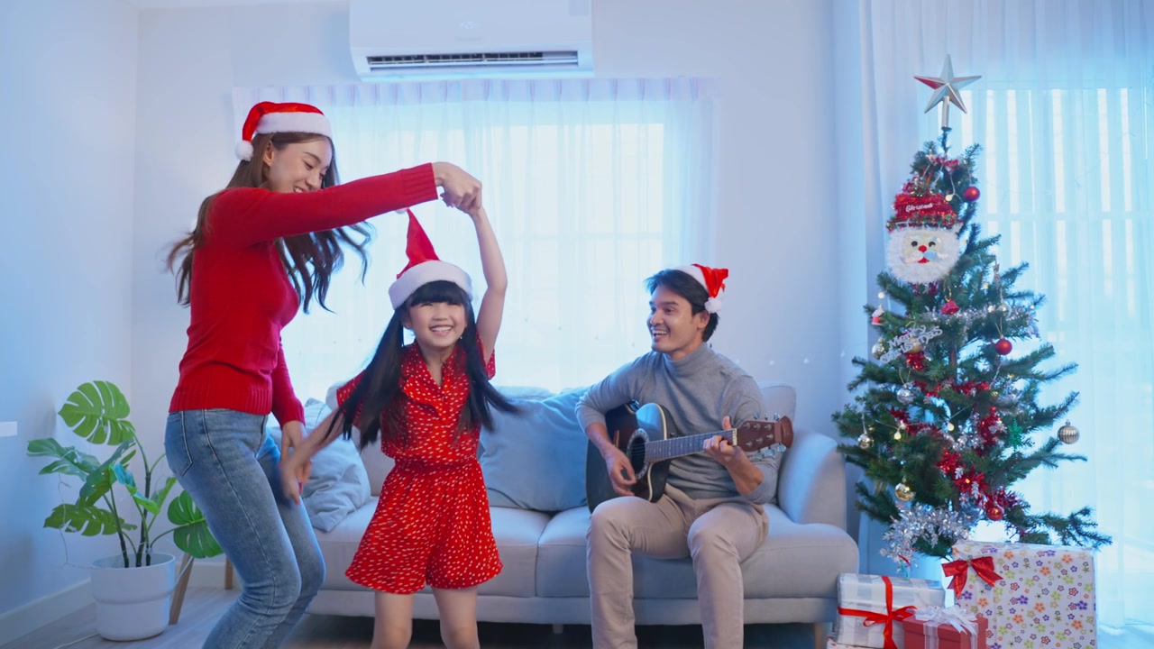 詳情圖-亞洲可愛的家庭成員在家里一起享受唱圣誕歌。年幼的女兒興高采烈地在家里和父母一起慶祝節(jié)日圣誕感恩節(jié)派對。