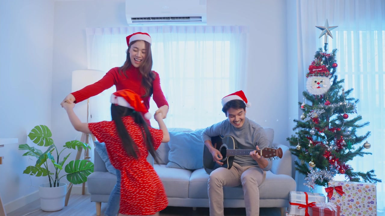 詳情圖-亞洲可愛的家庭成員在家里一起享受唱圣誕歌。年幼的女兒興高采烈地在家里和父母一起慶祝節(jié)日圣誕感恩節(jié)派對。