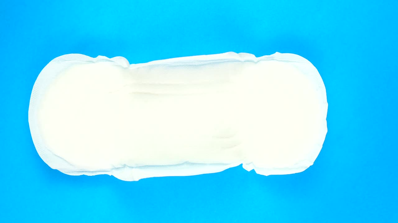 女性月经垫在蓝色背景上旋转