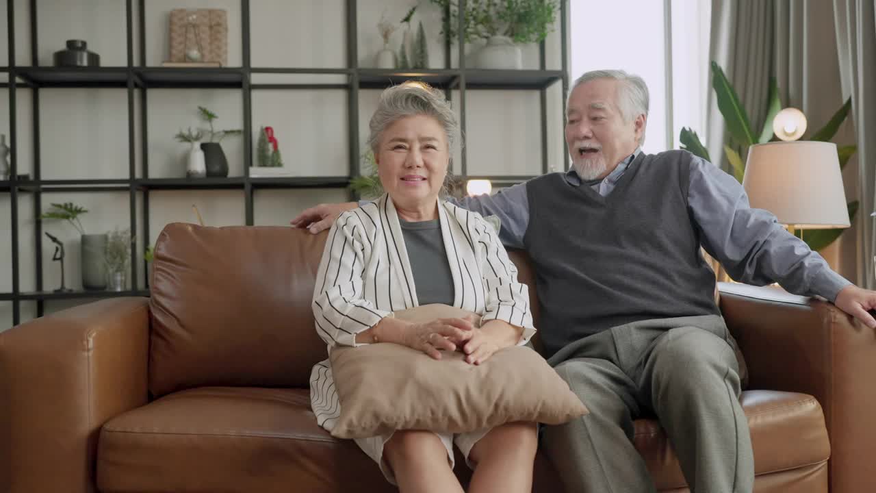 幸福亚洲家庭坦诚的女儿和儿子拥抱祖父母妈妈年长的妈妈舒适放松在沙发沙发惊喜访问在家里的客厅，一起拥抱快乐的亚洲家庭在家里