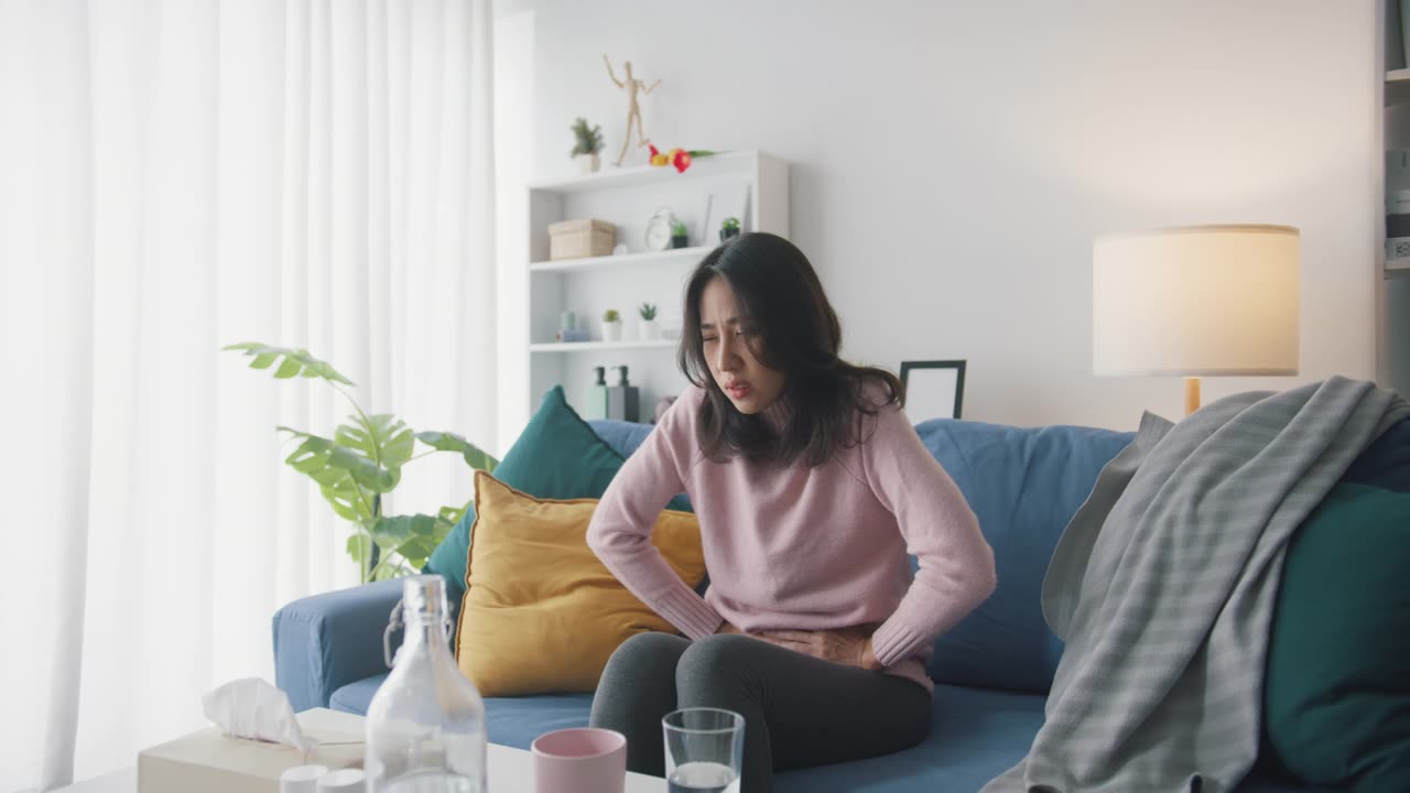 詳情圖-生病的亞洲婦女胃痛坐在沙發(fā)上客廳在家里。