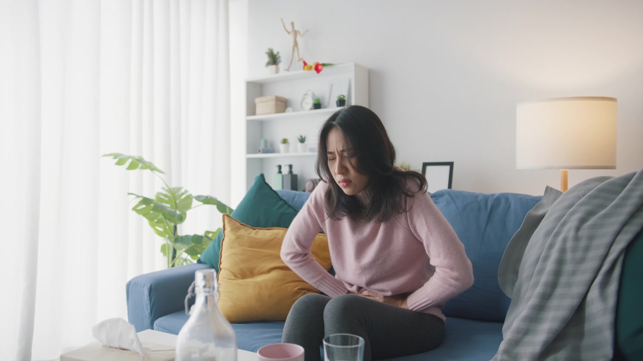 詳情圖-生病的亞洲婦女胃痛坐在沙發(fā)上客廳在家里。