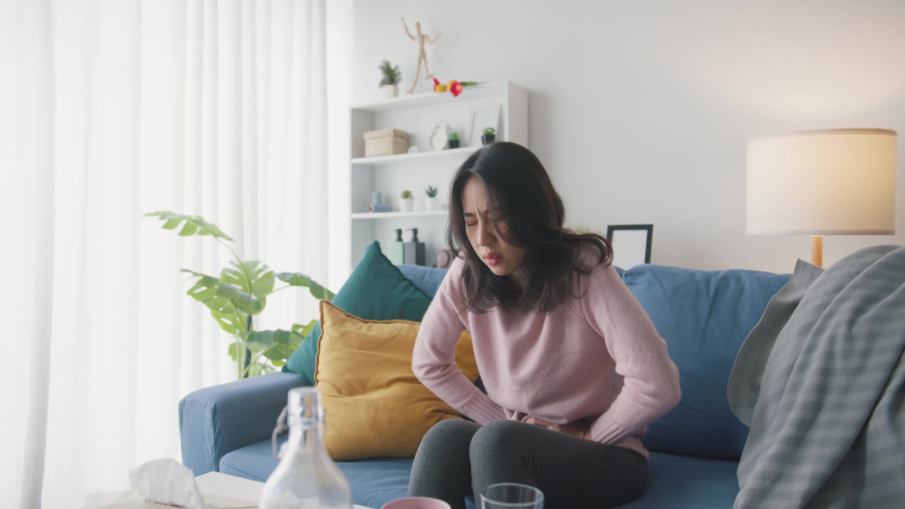詳情圖-生病的亞洲婦女胃痛坐在沙發(fā)上客廳在家里。