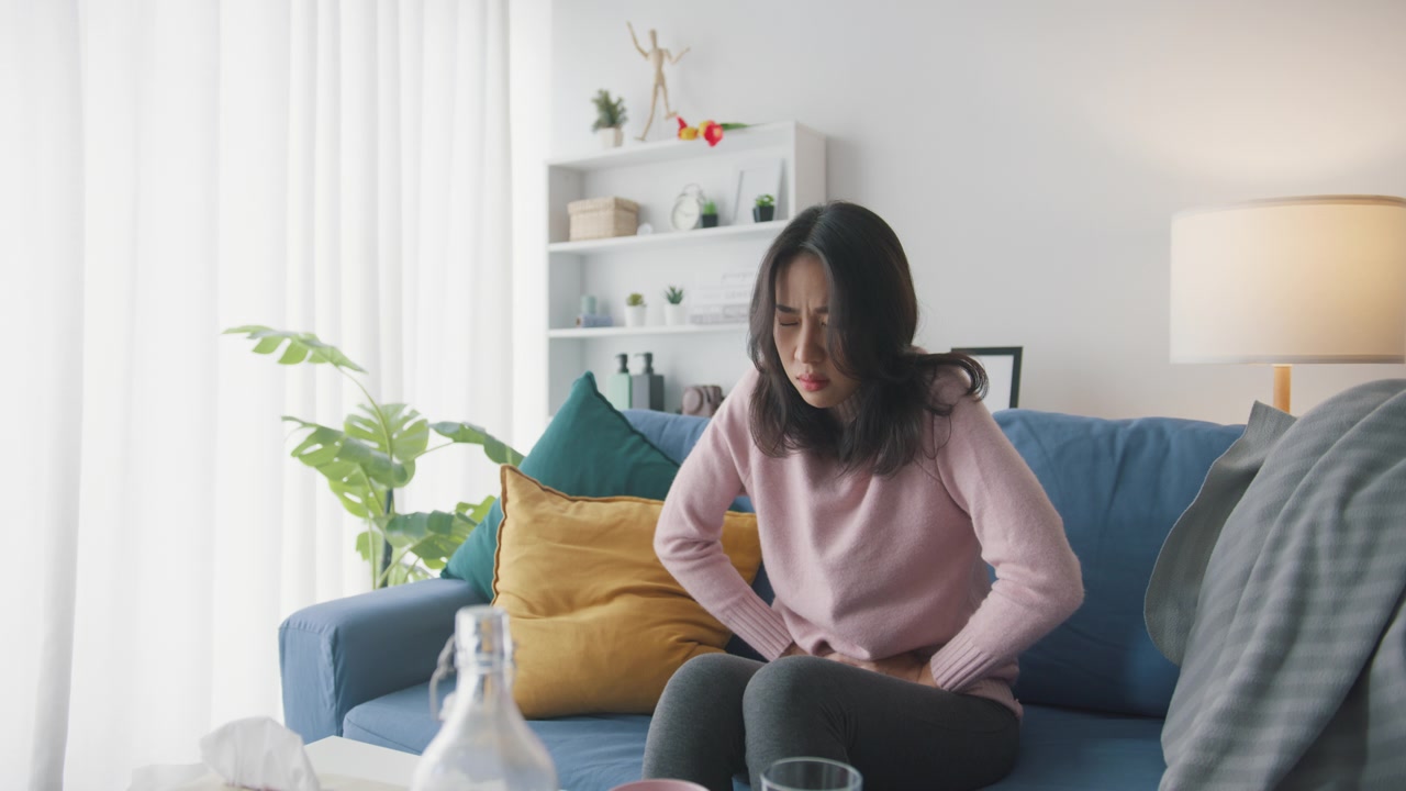 詳情圖-生病的亞洲婦女胃痛坐在沙發(fā)上客廳在家里。