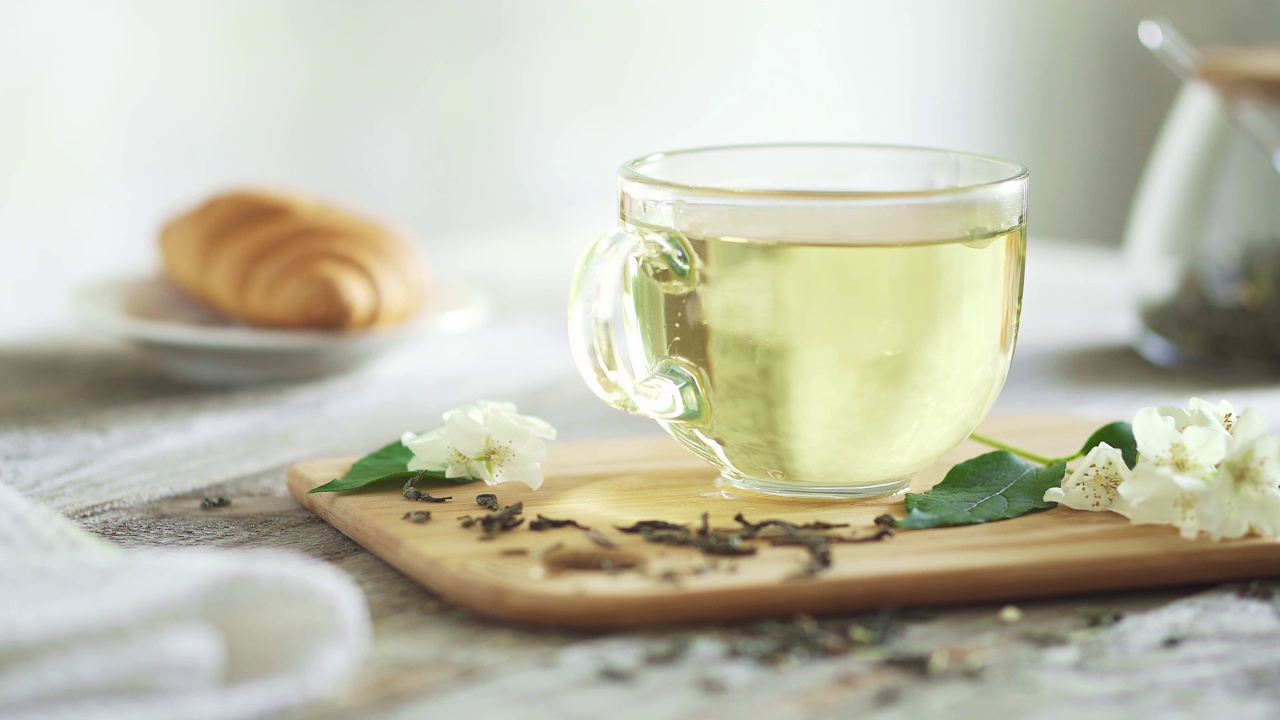 詳情圖-一杯茉莉花茶在玻璃杯中噴涌而出。透明杯，竹板，茉莉花枝