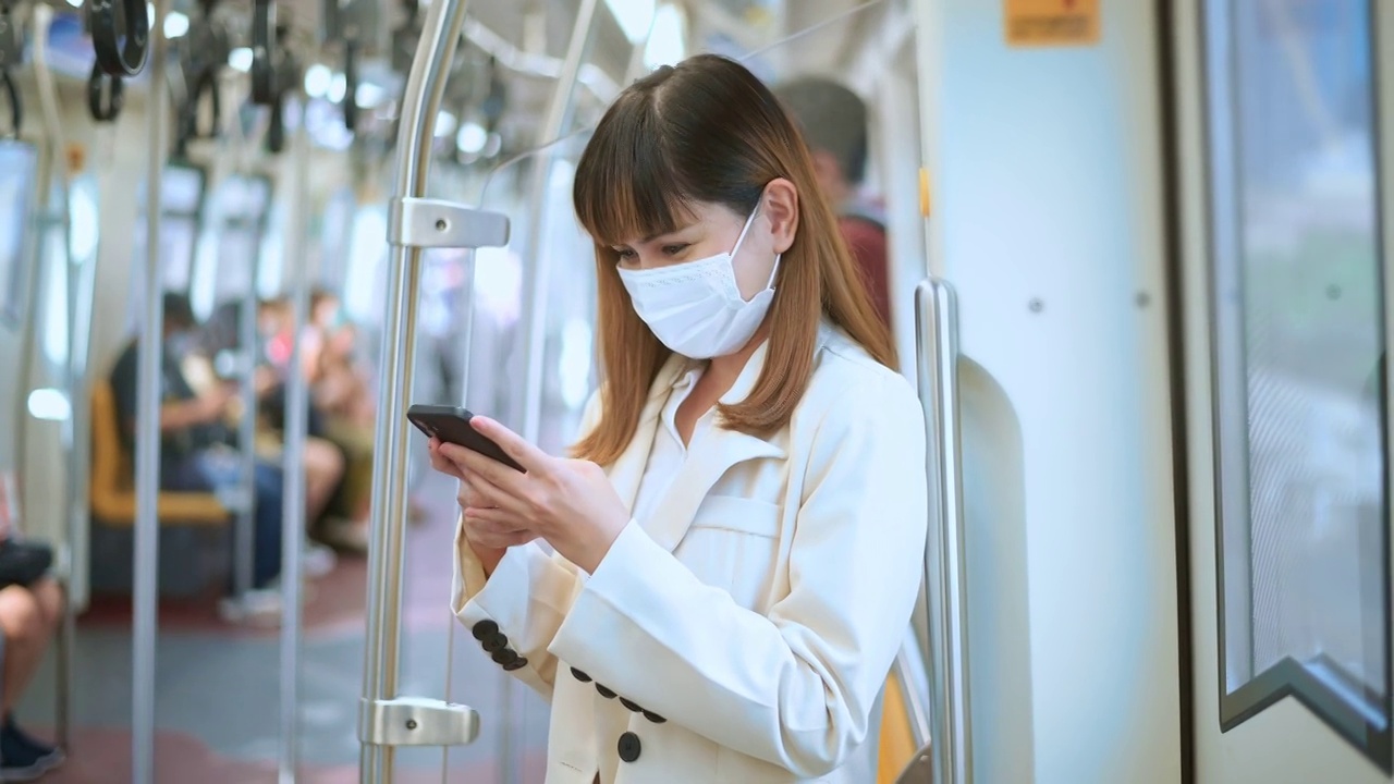 詳情圖-年輕女性在地鐵、新冠肺炎防護(hù)、安全出行、新常態(tài)、保持社交距離、安全出行、大流行理念下佩戴防護(hù)口罩