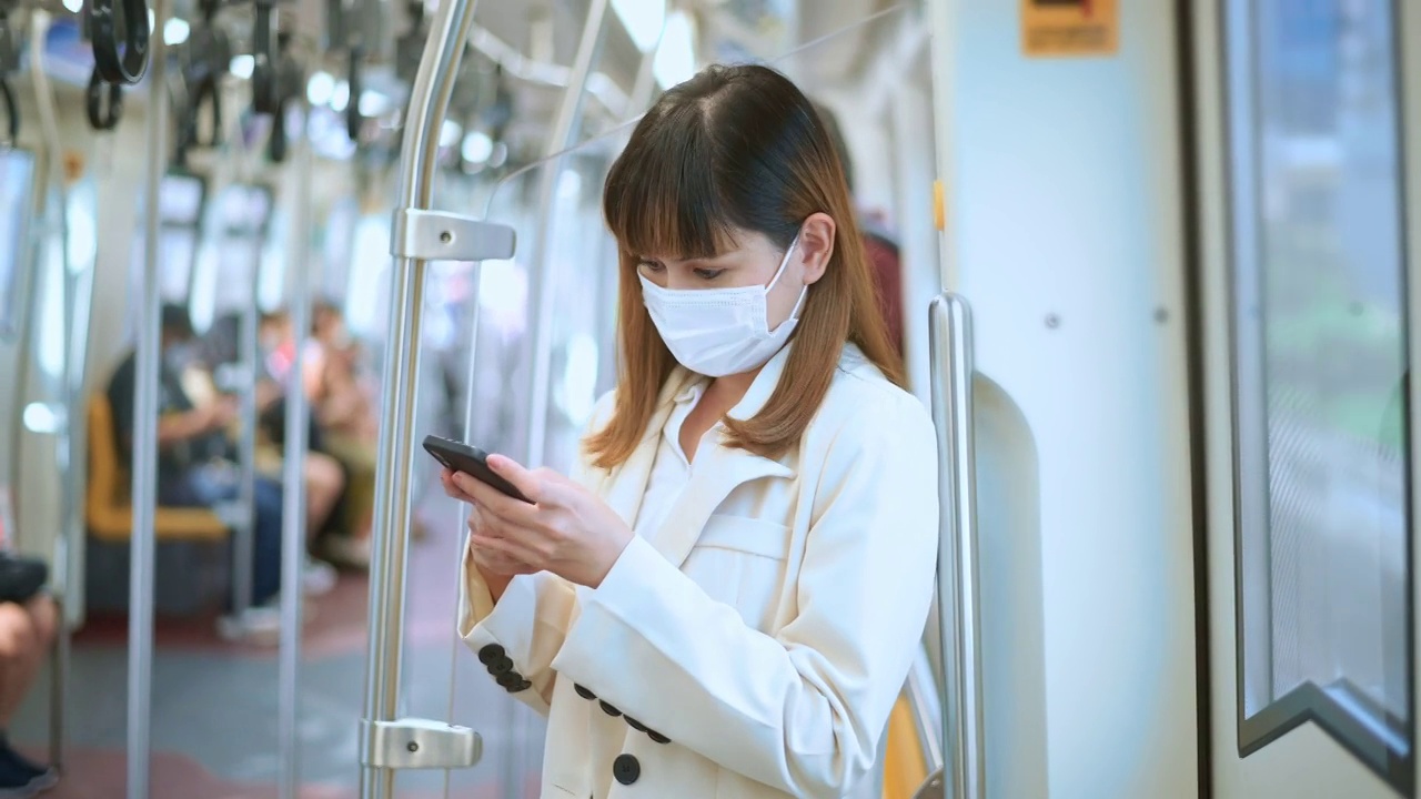 詳情圖-年輕女性在地鐵、新冠肺炎防護(hù)、安全出行、新常態(tài)、保持社交距離、安全出行、大流行理念下佩戴防護(hù)口罩