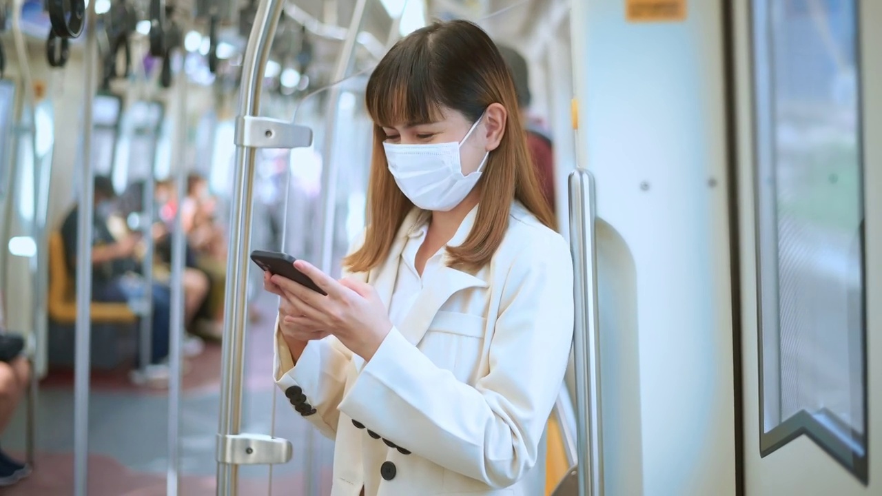 詳情圖-年輕女性在地鐵、新冠肺炎防護(hù)、安全出行、新常態(tài)、保持社交距離、安全出行、大流行理念下佩戴防護(hù)口罩