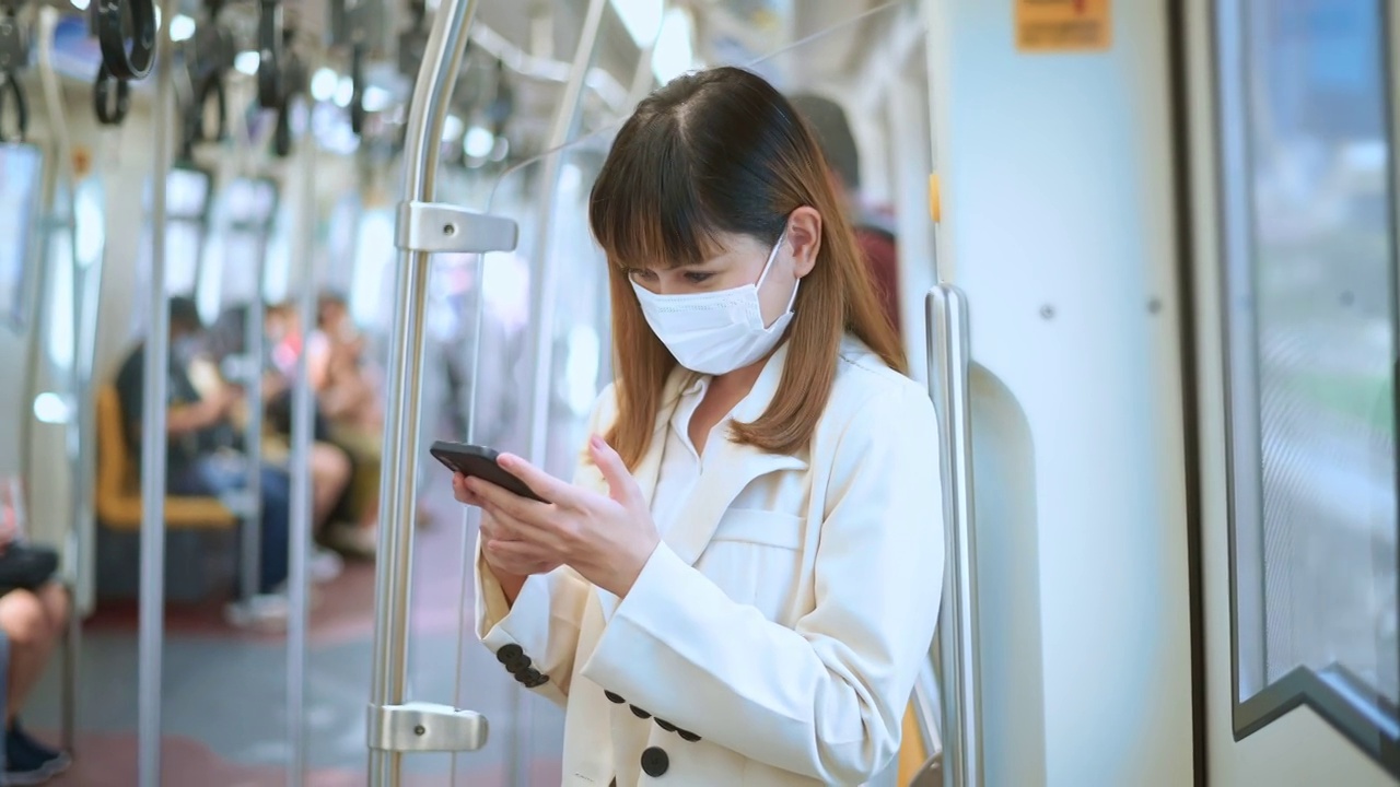 詳情圖-年輕女性在地鐵、新冠肺炎防護(hù)、安全出行、新常態(tài)、保持社交距離、安全出行、大流行理念下佩戴防護(hù)口罩