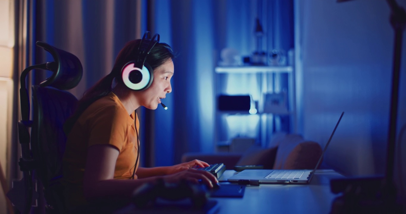 詳情圖-年輕的亞洲女性在晚上用筆記本電腦玩電腦游戲