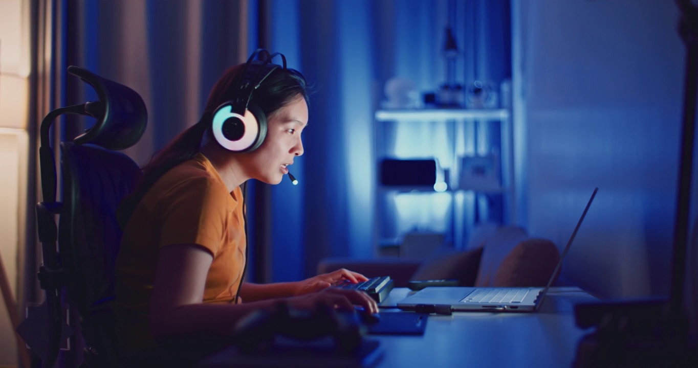 詳情圖-年輕的亞洲女性在晚上用筆記本電腦玩電腦游戲