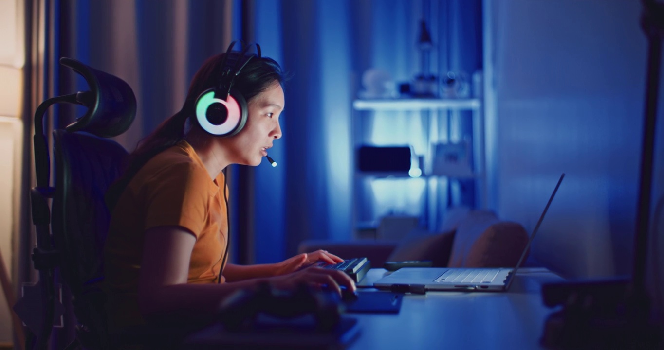 詳情圖-年輕的亞洲女性在晚上用筆記本電腦玩電腦游戲