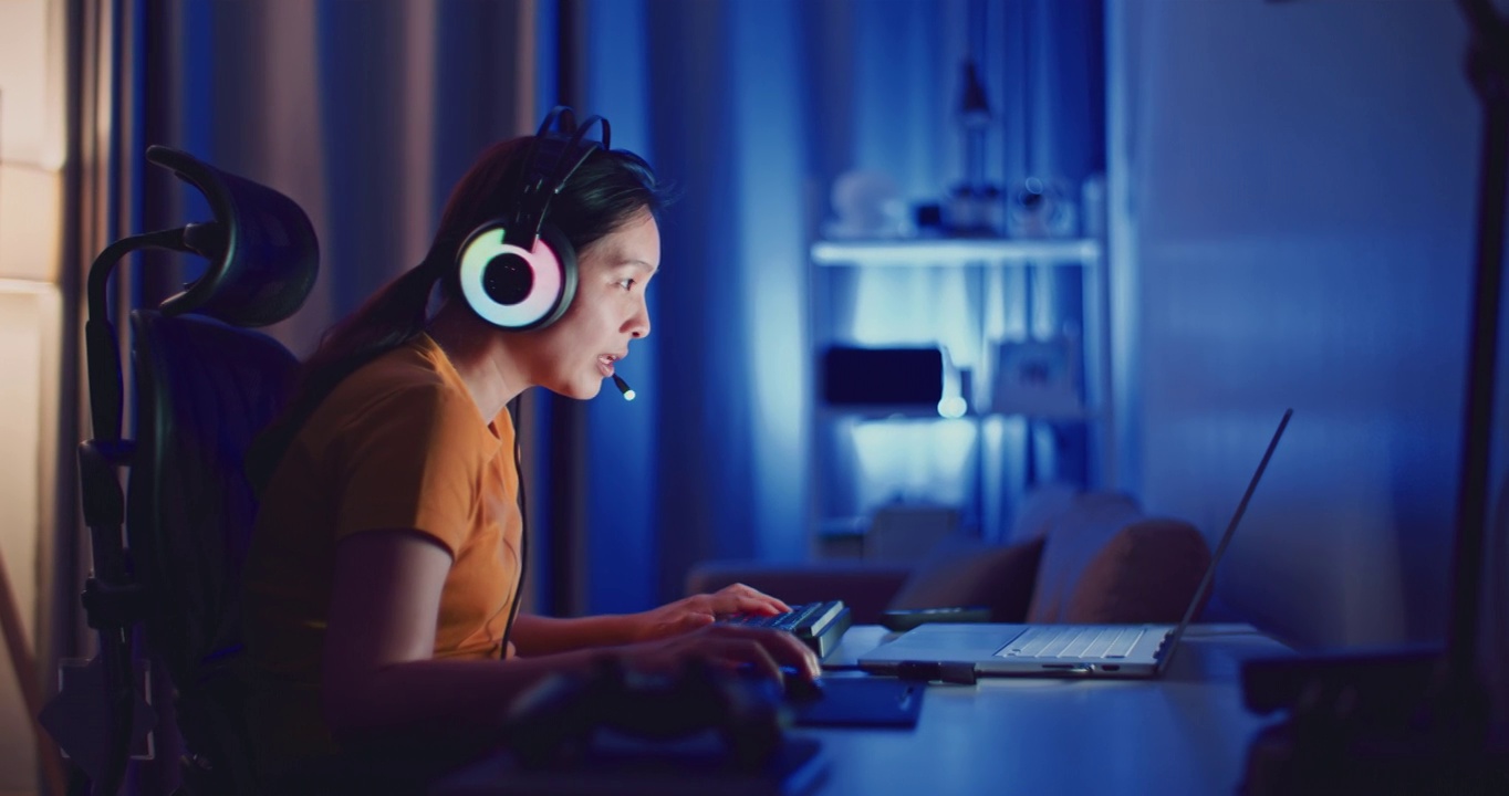 詳情圖-年輕的亞洲女性在晚上用筆記本電腦玩電腦游戲