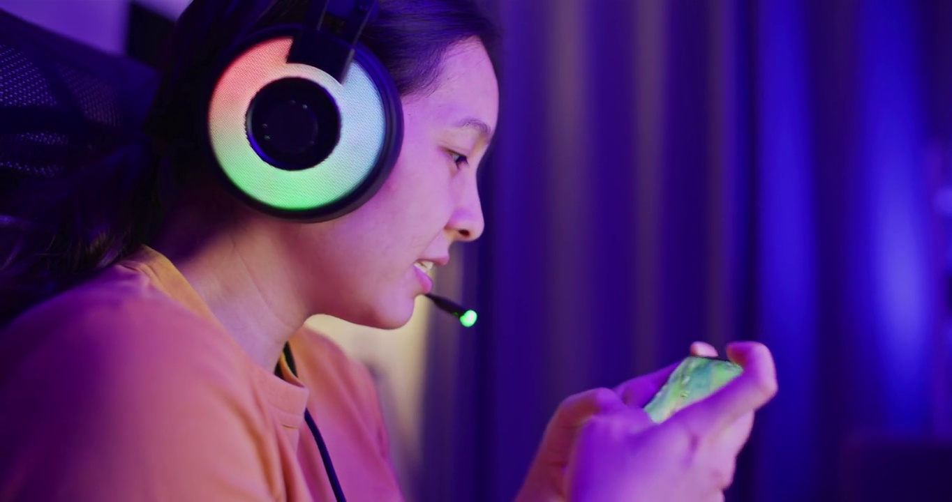 详情图-亚洲女性在家中客厅用智能手机玩网络游戏