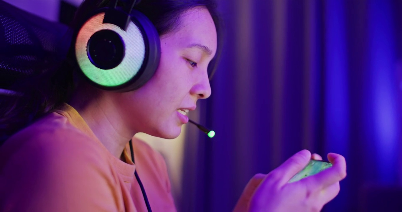 详情图-亚洲女性在家中客厅用智能手机玩网络游戏