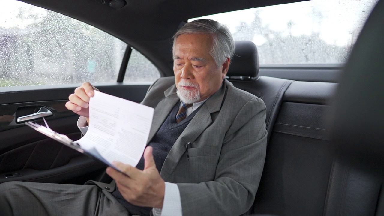 詳情圖-4K亞洲資深商人坐在車后座寫商業計劃