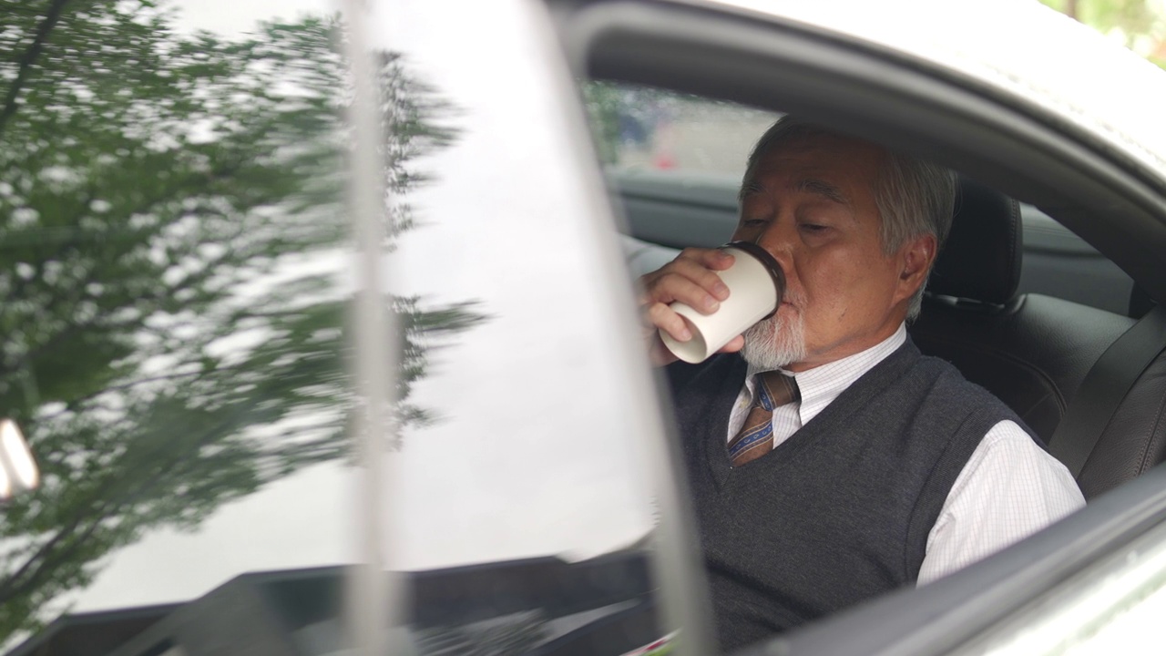 詳情圖-4K亞洲資深商人坐在汽車后座，一邊喝著熱咖啡，一邊在數(shù)碼平板電腦上工作