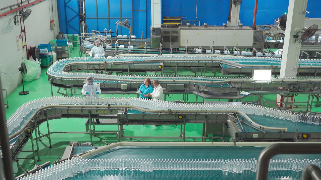亚洲中国工厂检验员和领班在生产线上与生产线工人的工作背景讨论矿泉水质量和生产进度