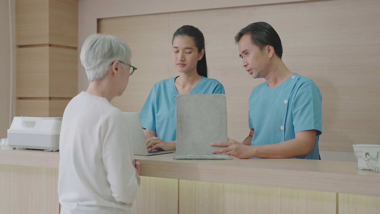 成年男性医生在医院接待老年病人。