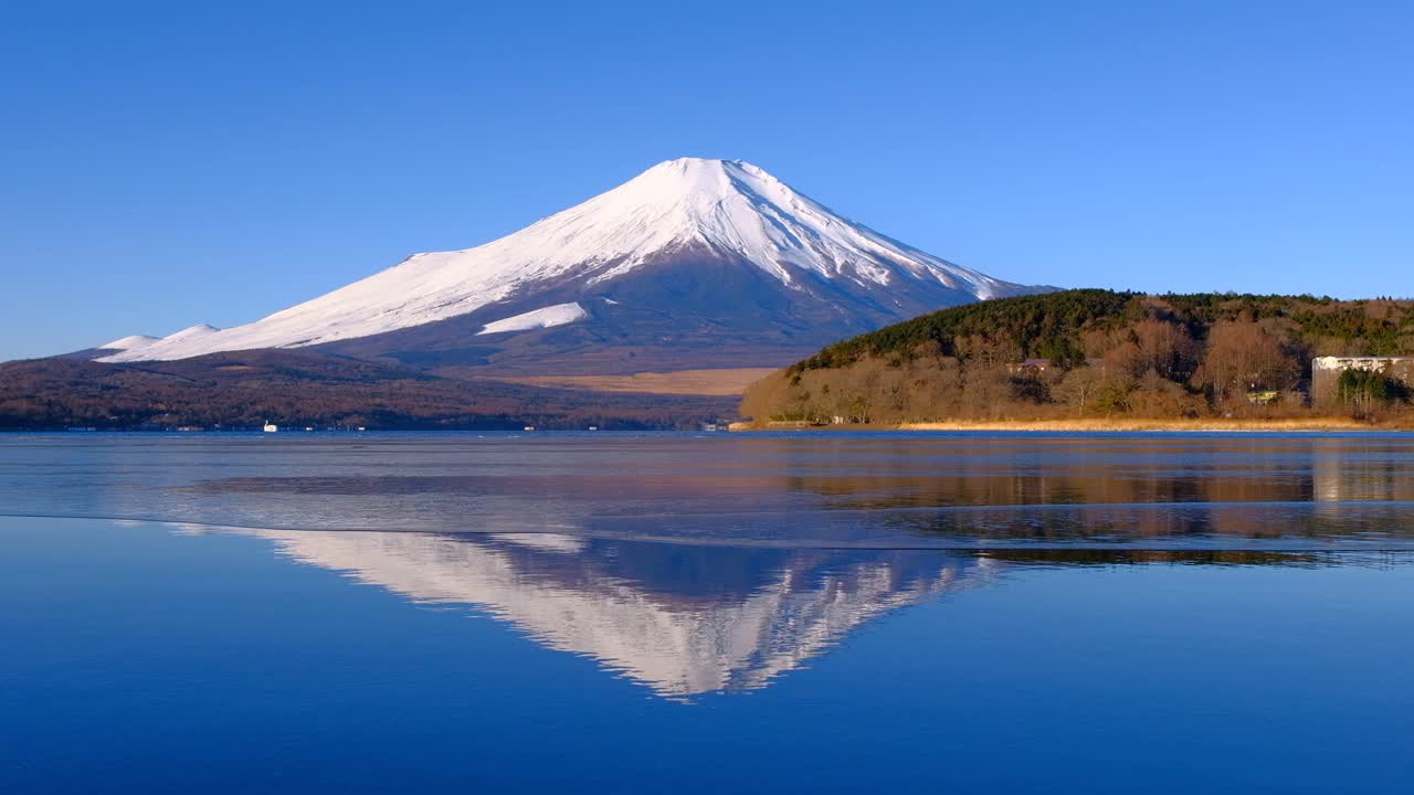 從冰凍的山中湖上倒立的富士山和藍天