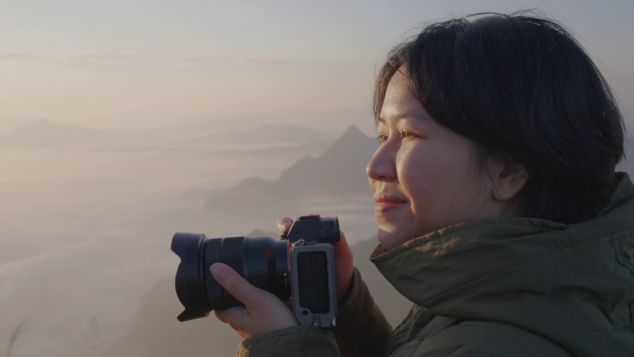 女背包客在摄影之旅中悠闲地捕捉雾山的形象。