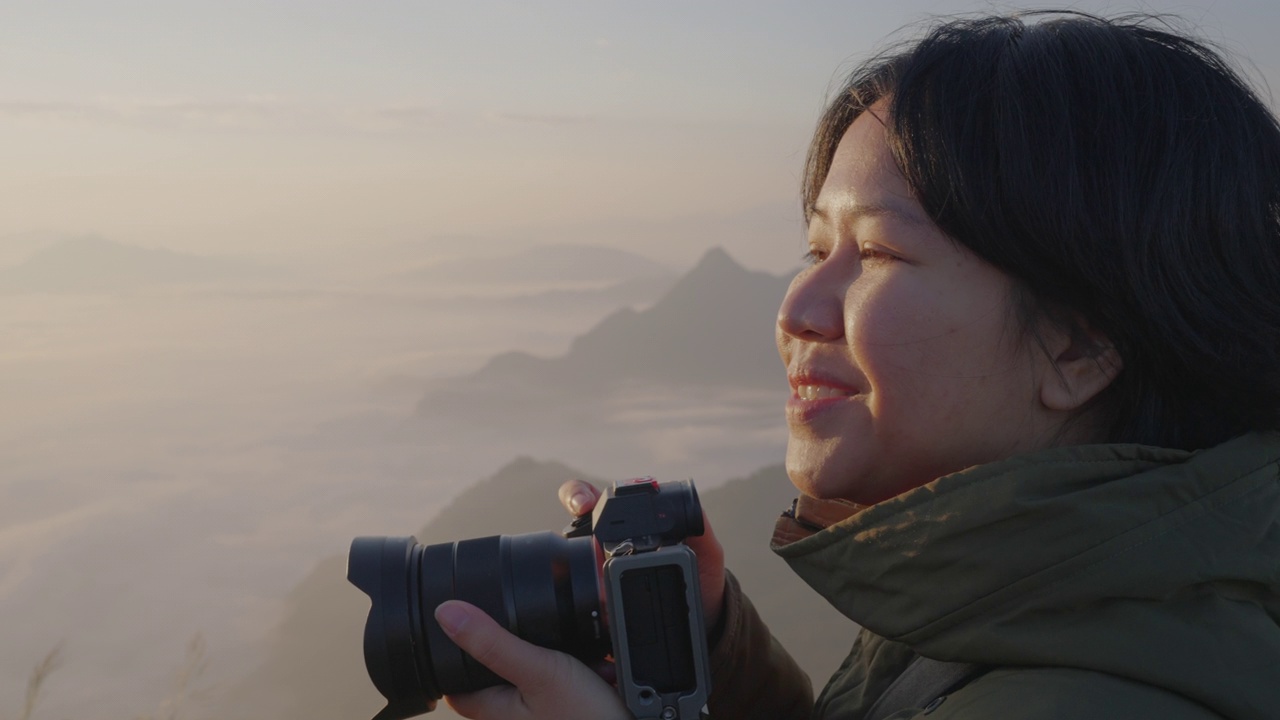 详情图-女背包客在摄影之旅中悠闲地捕捉雾山的形象。