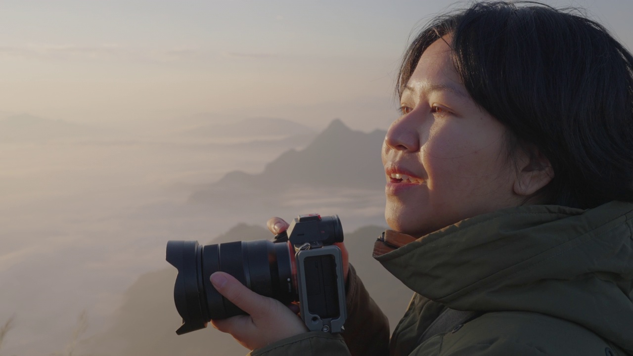 详情图-女背包客在摄影之旅中悠闲地捕捉雾山的形象。