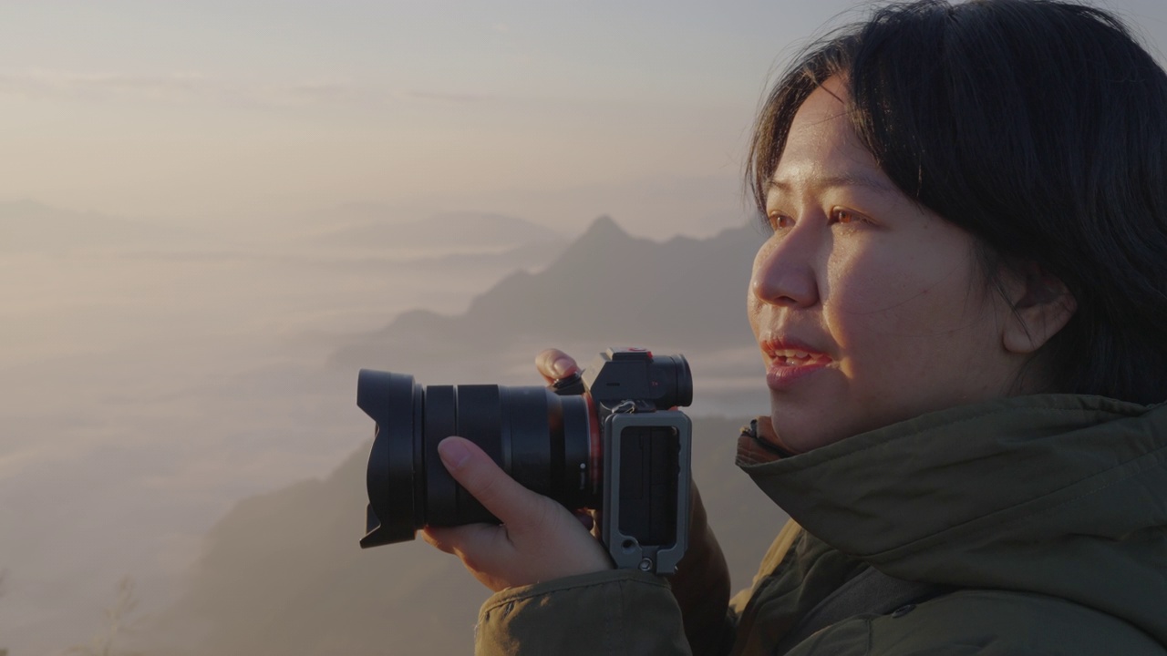 详情图-女背包客在摄影之旅中悠闲地捕捉雾山的形象。